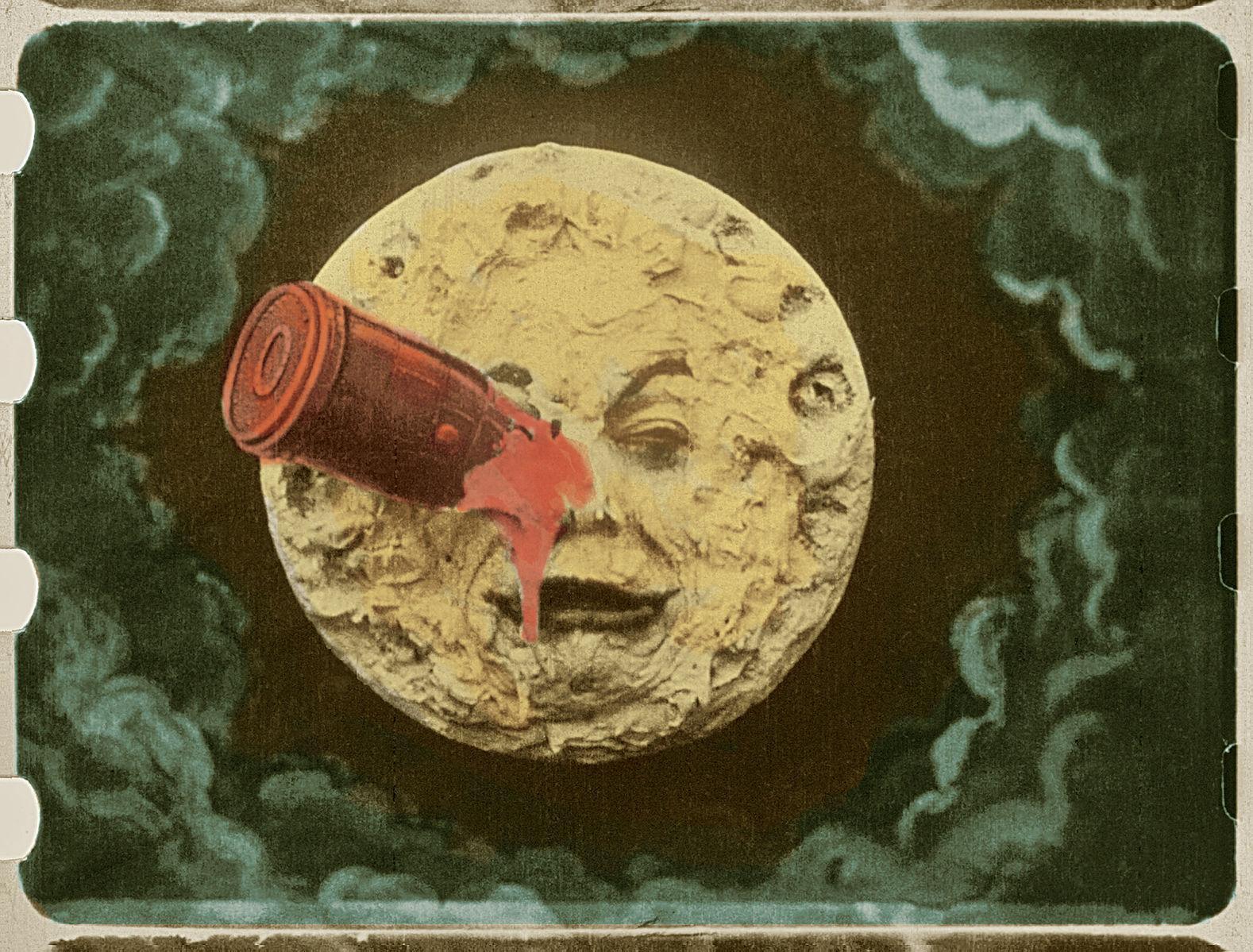 Image of a moon with a face & a red rocket in its eye